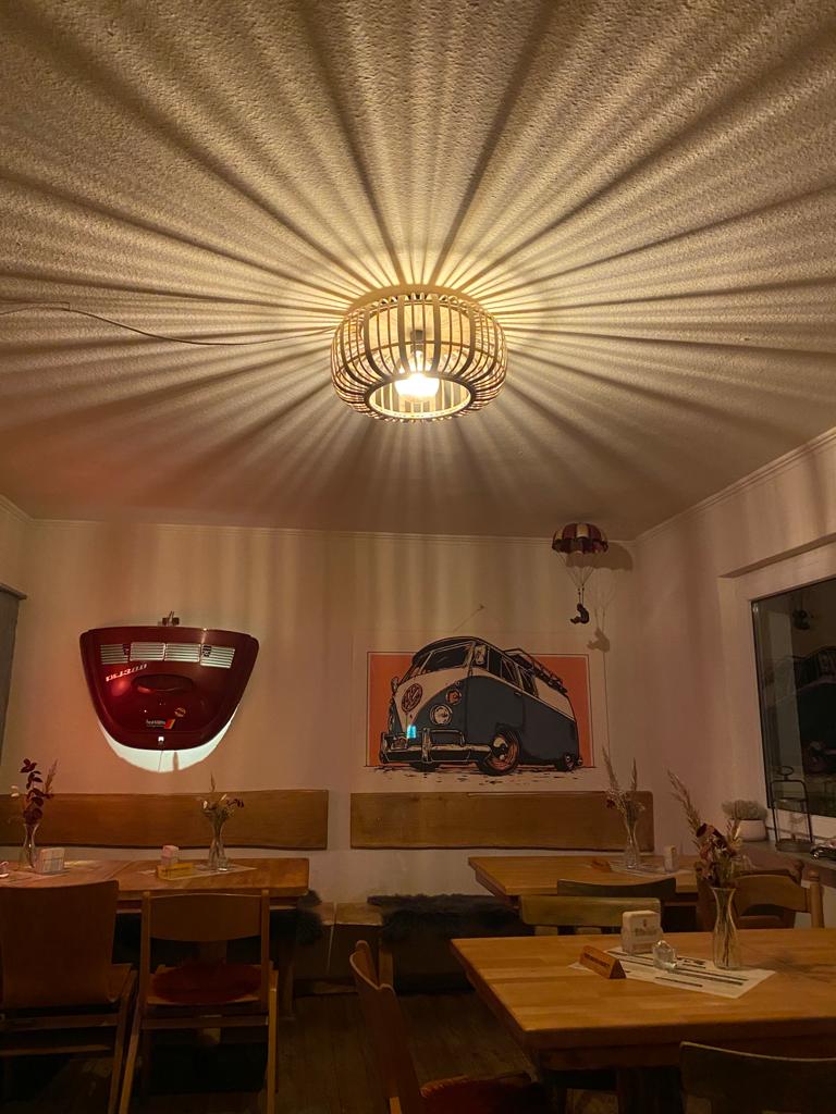 Gemütlicher Gastraum mit VW-Bus-Kunst und warmer Beleuchtung